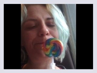 Blue haired girl licks and sucks lollipop